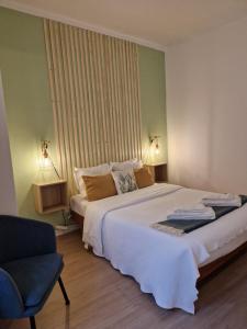 a bedroom with a large white bed and a chair at Bea's Bed & Breakfast in Tavira