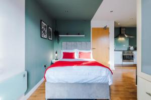 a bedroom with a large bed with red and white pillows at Stylish and Comfy Studio in Sheffield City Centre in Sheffield