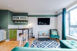 a living room with green and white walls and a kitchen at Stylish and Comfy Studio in Sheffield City Centre in Sheffield