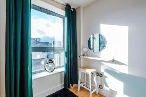 a room with a window with a chair and a stool at Stylish and Comfy Studio in Sheffield City Centre in Sheffield