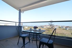 a table and chairs in a room with a large window at Olympus Diamond studios in Olympic Beach