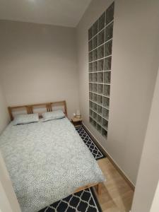 ein Schlafzimmer mit einem Bett und einer Wand mit Glasflaschen in der Unterkunft Apartament Zacisze 3 modern in Częstochowa
