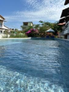 uma piscina com água azul em frente a uma casa em Inn Tribus Hotel em Flecheiras