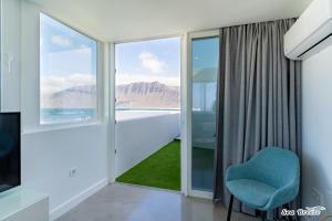 カレタ・デ・ファマラにあるApartamentos Sea Breezeの窓と青い椅子が備わる客室です。