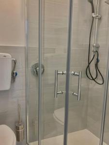 y baño con ducha y puerta de cristal. en Central Seaview Apartment en Lerici