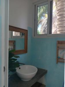 a bathroom with a white bowl sink and two windows at El Puente in El Paredón Buena Vista