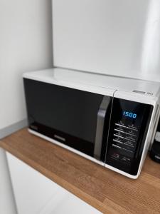 a microwave oven sitting on a wooden shelf at Modern 1 bedroom apartament in Turnu Măgurele