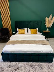 duże łóżko z żółtymi poduszkami w zielonym pokoju w obiekcie Modern 1 bedroom apartament w mieście Turnu Măgurele