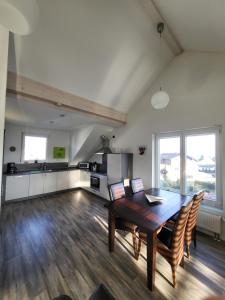 ein Wohnzimmer mit einem Holztisch und Stühlen in der Unterkunft Ferienwohnung in Elz bei Limburg an der Lahn in Elz