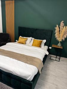 1 dormitorio con 1 cama grande con almohadas amarillas en Modern 1 bedroom apartament en Turnu Măgurele