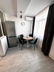 Turnu MăgureleにあるGarsoniera moderna One bedroomのダイニングルーム(テーブル、椅子、冷蔵庫付)
