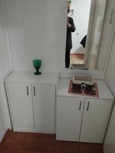 een badkamer met witte kasten en een spiegel bij Apartman Mikica in Vrnjci