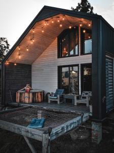 a house with a deck with a hot tub and lights at Карпатське Hygge котедж для двох з чаном-джакузі у горах in Slavske
