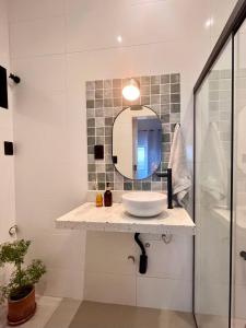 La salle de bains est pourvue d'un lavabo et d'un miroir. dans l'établissement Apartamento Glória, à Rio de Janeiro