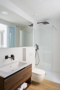 Baño blanco con lavabo y aseo en Luxury Houses La Mar de Bonita en Guardamar del Segura
