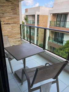 d'une table et d'un banc sur un balcon. dans l'établissement Apartamento no Illoa Residente na Barra de São Miguel, à Barra de São Miguel