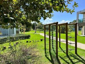 une balançoire dans un parc avec une cour dans l'établissement Apartamento no Illoa Residente na Barra de São Miguel, à Barra de São Miguel