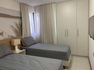 - une petite chambre avec 2 lits et une fenêtre dans l'établissement Apartamento no Illoa Residente na Barra de São Miguel, à Barra de São Miguel