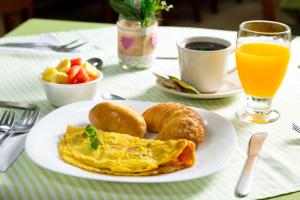 a plate with an omelet and croissants on a table at Hotel Stein Colonial in Cali