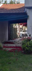 un patio con fiori nell'erba accanto a un edificio di Casa Hostel A 15 minutos de Aeropuerto Ezeiza a Monte Grande