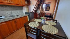 uma cozinha com uma mesa com cadeiras e um lavatório em LS Resthouse with pool and garden em Calapan