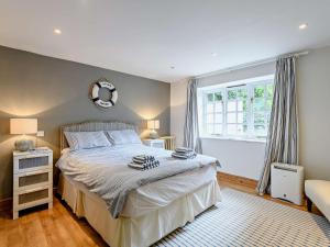um quarto com uma cama grande e uma janela em 4 Bed in Lulworth Cove DC176 em West Lulworth