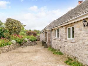 a stone cottage with a pathway next to a building at 3 Bed in Worth Matravers DC140 in Worth Matravers