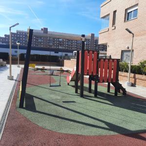 un parque infantil con bancos rojos en una calle en Apartamento Marina D'Or, en Oropesa del Mar