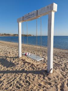 a swing on a beach with the ocean in the background at Luxury Chalet in Mountain View 2 , El-Sokhna with Sea View , Pool View and Garden View Families Only in Ain Sokhna