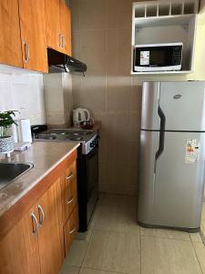 a kitchen with a stainless steel refrigerator and a microwave at Departamento en Colastine Norte in Colastiné