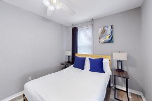 - une chambre avec un grand lit blanc et des oreillers bleus dans l'établissement Mid America House, à Midwest City