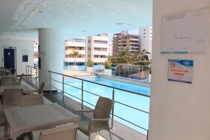 un balcón con piscina, mesas y sillas en Hotel Atlantic Lux, en Cartagena de Indias