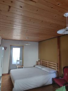a bedroom with a large bed with a wooden ceiling at San Carlo in Chiavenna