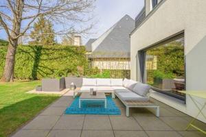 un patio con sofá blanco y mesa de centro en Palatial Home - Sauna & Private Yard ID94, en Dippach