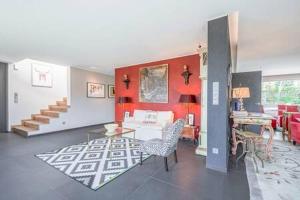 ein Wohnzimmer mit roten Wänden, einem Sofa und Stühlen in der Unterkunft Charming 3BR with Balcony, Yard & Sauna in Dippach