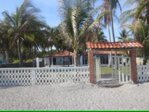 una casa en la playa con una valla y palmeras en Vistabella Beach House - Pool, Beach - 12ppl, en El Porvenir