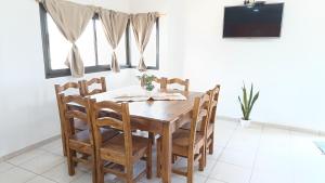 comedor con mesa de madera y sillas en Alojamiento Caroya in 