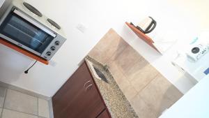 a kitchen with a tv and a counter with a chair at Alojamiento Caroya in Colonia Caroya