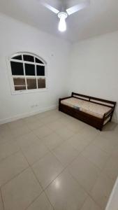 a white room with a bed and a window at Casa Praia dos Sonhos in Itanhaém