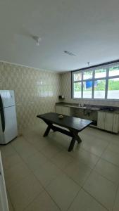 a kitchen with a table in the middle of a room at Casa Praia dos Sonhos in Itanhaém