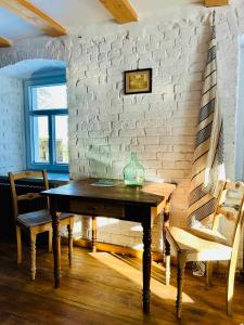 una mesa y sillas en una habitación con una pared de ladrillo en MałaKamienica80 Butikowa agroturystyka w Górach Izerskich 