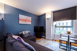 a living room with a couch and a large window at Best Nights Sleep with King Bed & Power Shower, Centrally located Parking available in Sheffield