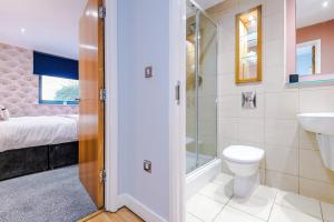 a bathroom with a shower and a toilet and a sink at Best Nights Sleep with King Bed & Power Shower, Centrally located Parking available in Sheffield
