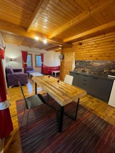 a living room with a wooden table and a kitchen at Villzone with big garden in Pristina