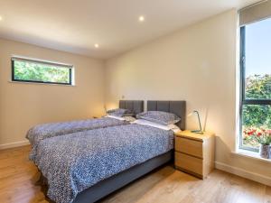 a bedroom with a bed and two windows at 2 Bed in Croyde 76783 in Croyde