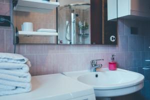 La salle de bains est pourvue d'un lavabo et de toilettes avec des serviettes. dans l'établissement B&B del Villaggio, à Argentera