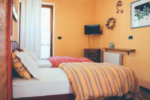 Un dormitorio con una cama con una manta a rayas. en B&B del Villaggio, en Argentera