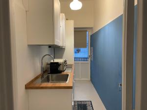 卡普里的住宿－Casa Amelia，厨房设有水槽和蓝色的墙壁