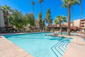 een groot zwembad met palmbomen in een resort bij 2BD Central To Old Town Pool & Spa Access in Scottsdale