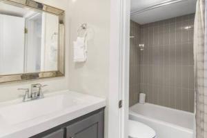a bathroom with a sink and a toilet and a mirror at The Scallop by Brightwild-Beachfront Condo in Destin +14 photos